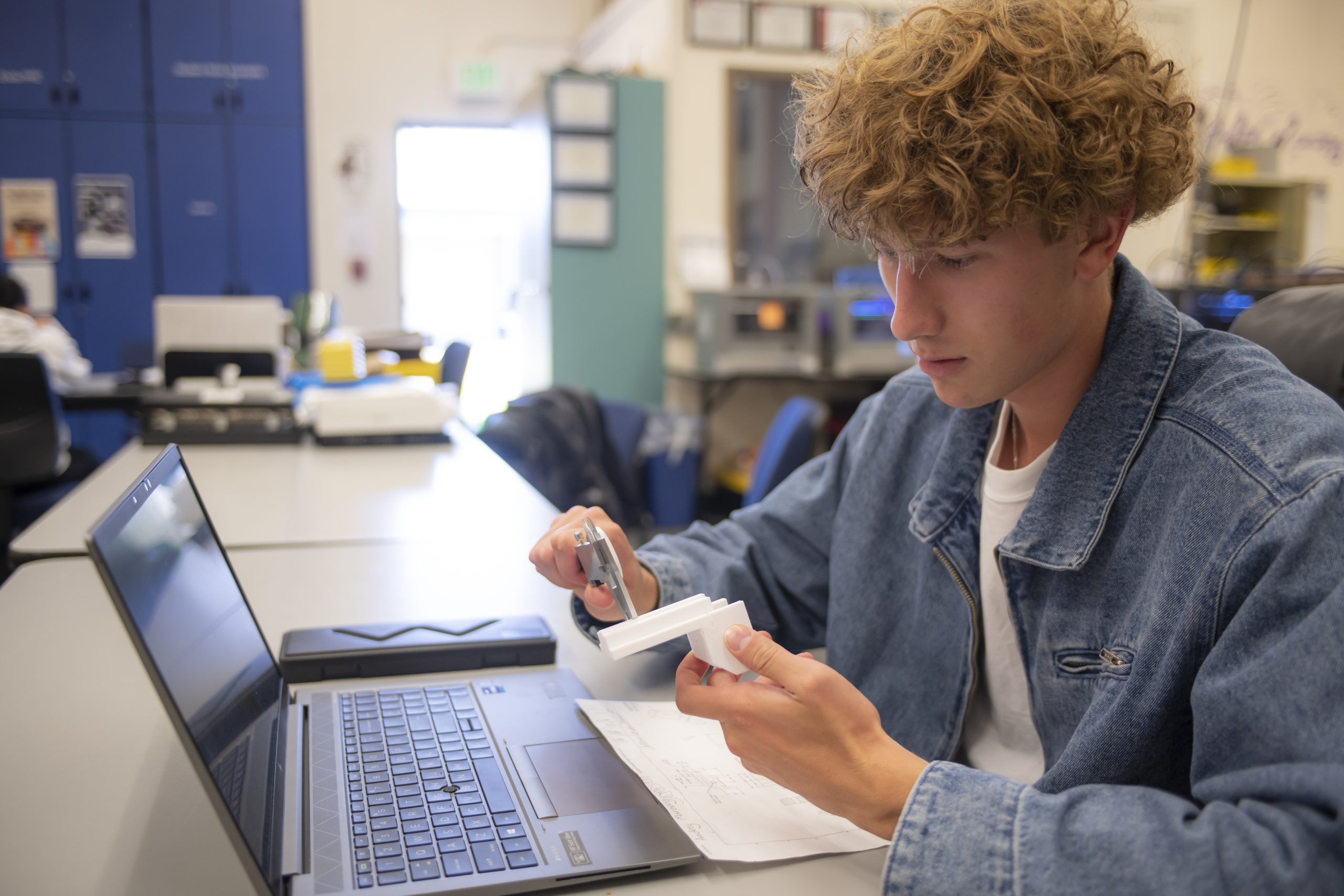 A student using a tool to measure.